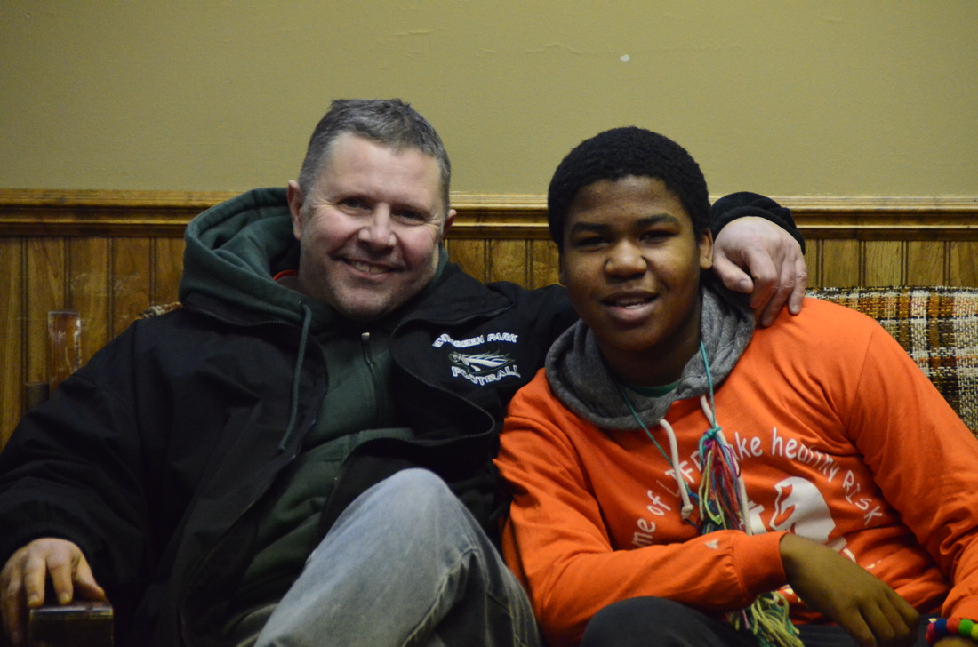 Ray Schellenberger with his arm around a smiling student